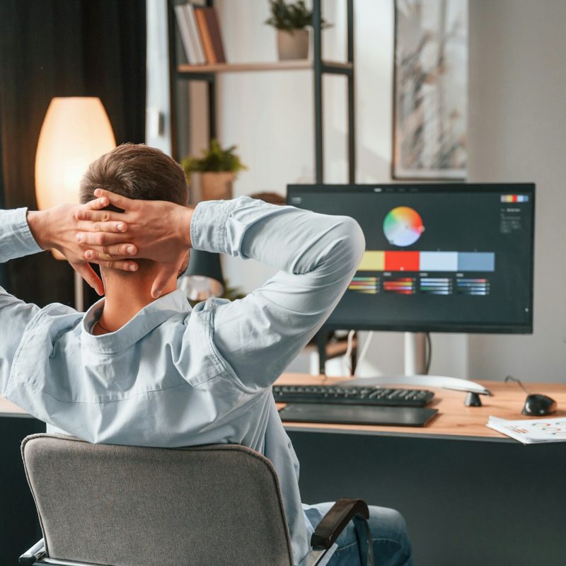 Designer is sitting by the computer and using graphics tablet with stylus